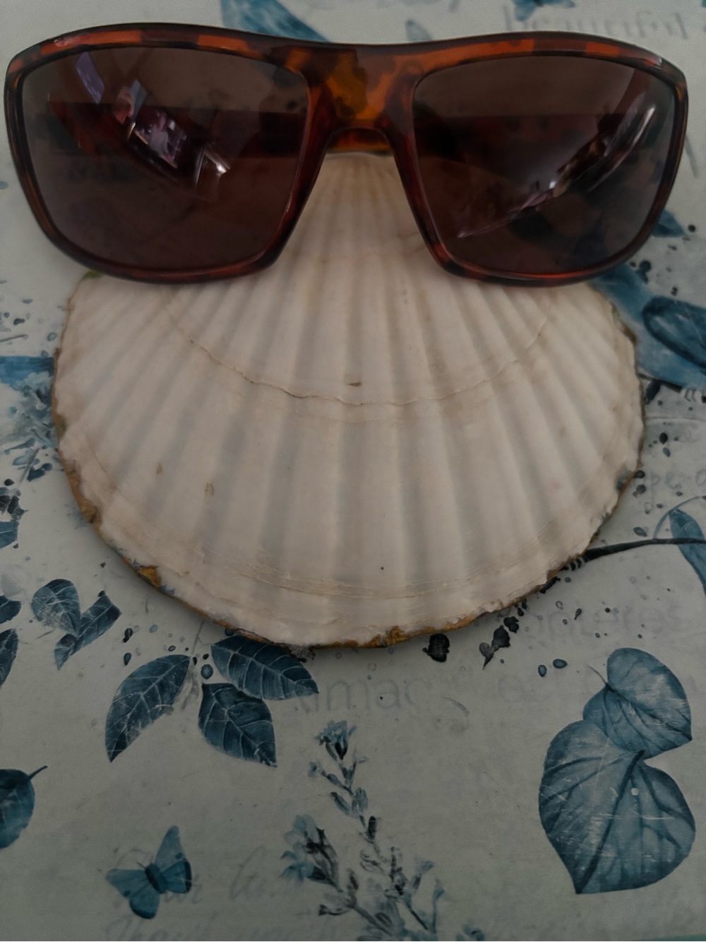 tortoiseshell wrap-around sunglasses with dark amber/brown tinted lenses.